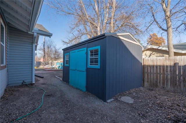 view of shed featuring fence