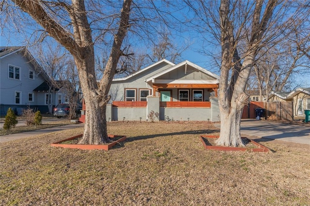 view of front facade with a residential view, concrete driveway, and a front lawn