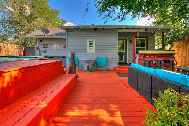 deck with a hot tub, fence, and outdoor lounge area