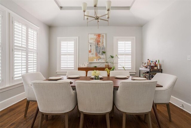 dining room with an inviting chandelier, dark wood-type flooring, and baseboards