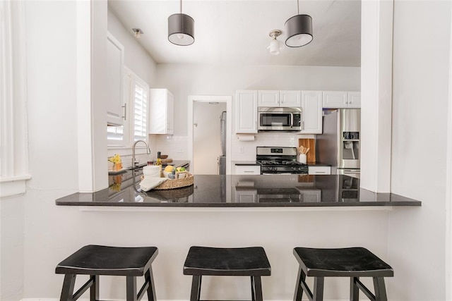 kitchen with decorative backsplash, a peninsula, white cabinetry, and stainless steel appliances