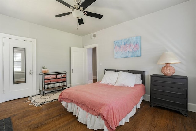 bedroom with ceiling fan, visible vents, baseboards, and wood finished floors