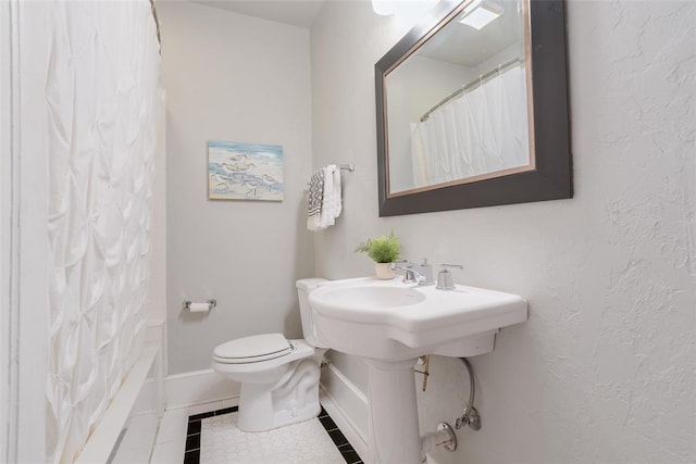 bathroom with a shower with curtain, baseboards, toilet, and tile patterned flooring