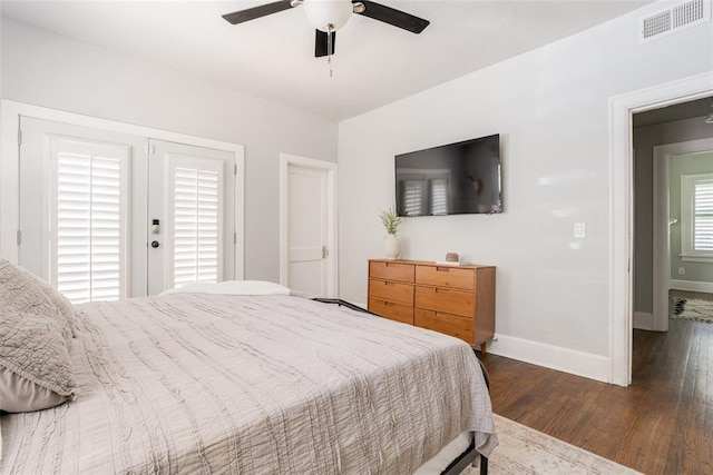 bedroom with visible vents, baseboards, wood finished floors, and a ceiling fan