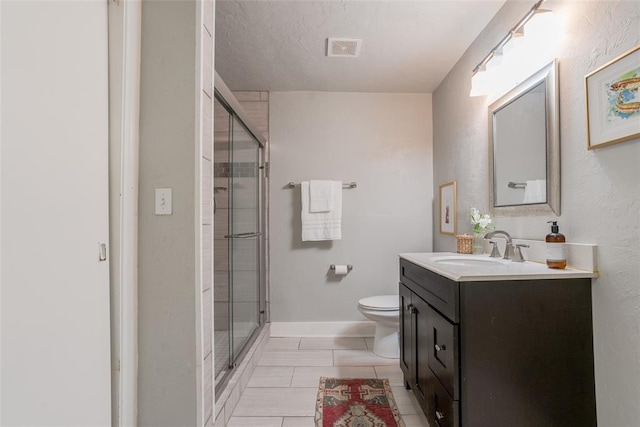 full bath with visible vents, a shower stall, baseboards, toilet, and vanity