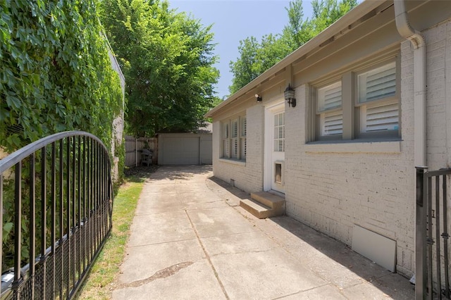 view of home's exterior featuring fence, entry steps, concrete driveway, a garage, and brick siding