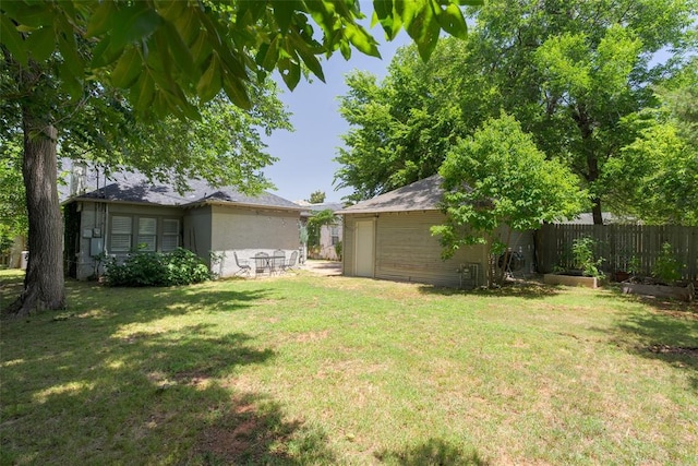 view of yard with a vegetable garden, an outdoor structure, and fence