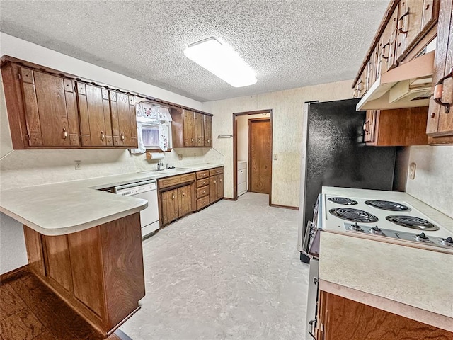 kitchen featuring sink, white appliances, kitchen peninsula, and a textured ceiling