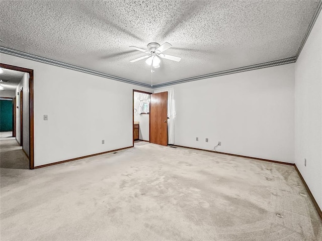 carpeted spare room featuring ceiling fan, ornamental molding, and a textured ceiling