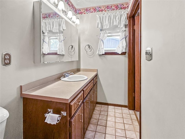 bathroom featuring tile patterned flooring, vanity, and toilet