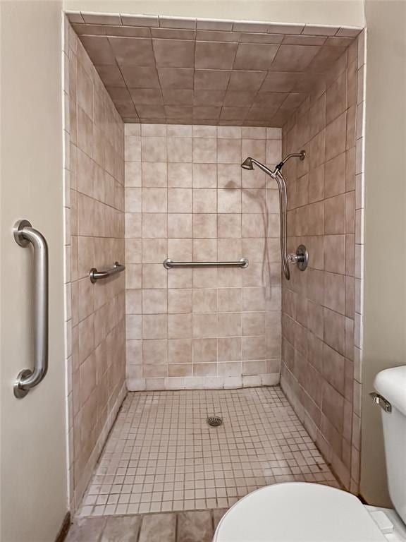 bathroom featuring tiled shower and toilet