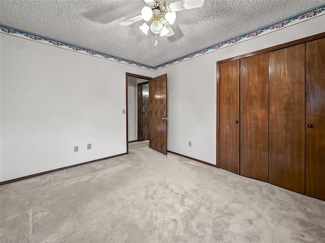 unfurnished bedroom featuring light carpet, ceiling fan, a closet, and a textured ceiling