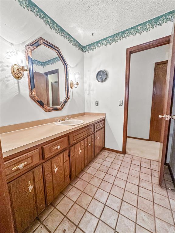 bathroom featuring vanity, tile patterned floors, and a textured ceiling