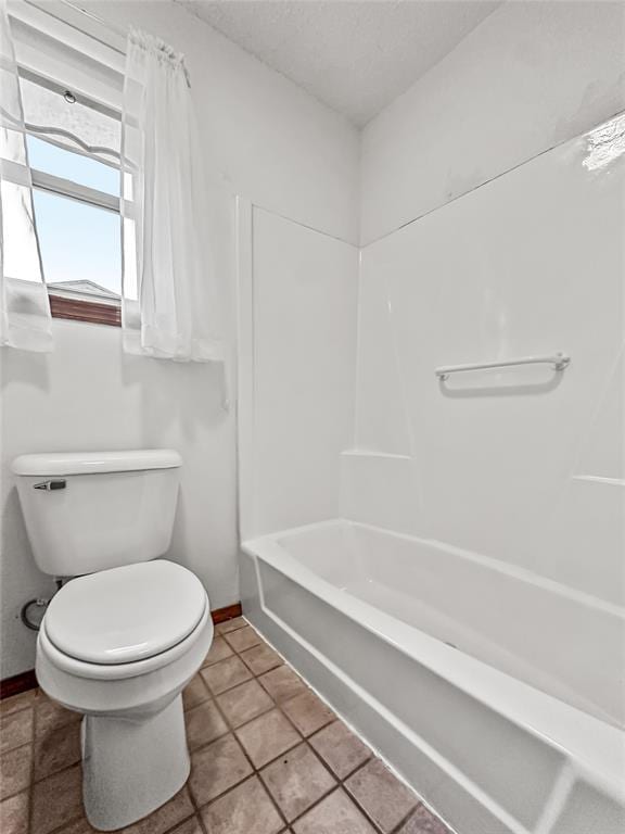 bathroom with shower / bathing tub combination, tile patterned floors, and toilet