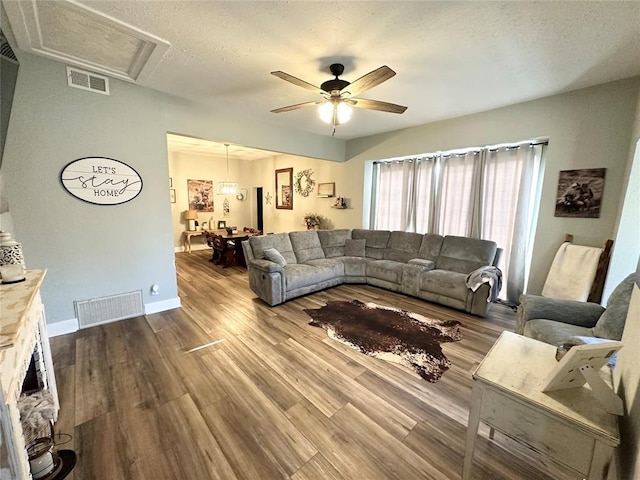 living room featuring hardwood / wood-style flooring, a textured ceiling, and ceiling fan