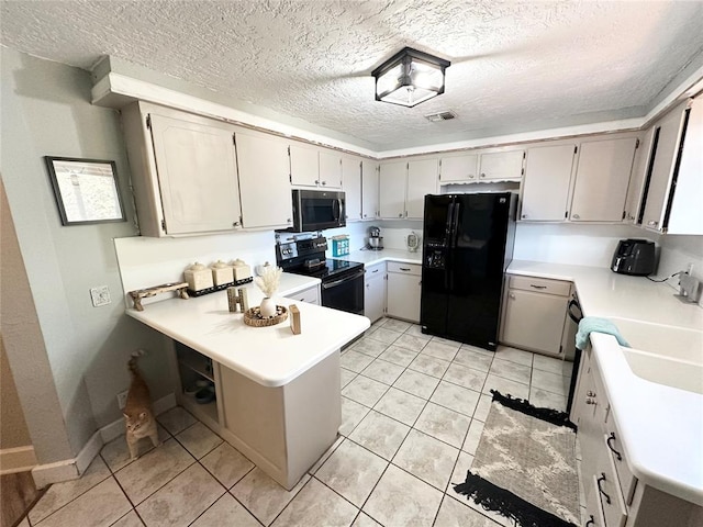 kitchen featuring light tile patterned floors, sink, black appliances, a textured ceiling, and kitchen peninsula