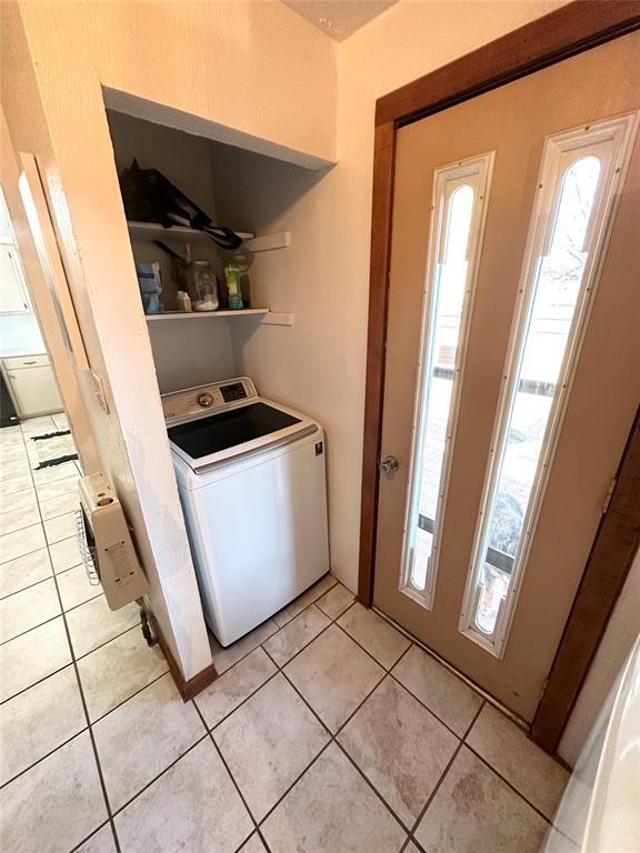 laundry area with light tile patterned flooring and washer / dryer