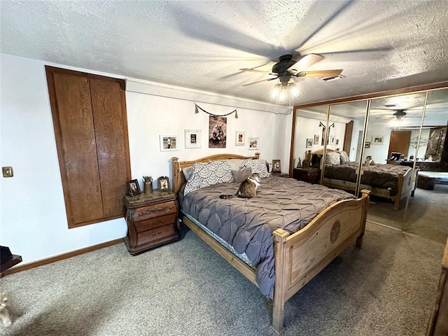 bedroom with ceiling fan, carpet flooring, a closet, and a textured ceiling