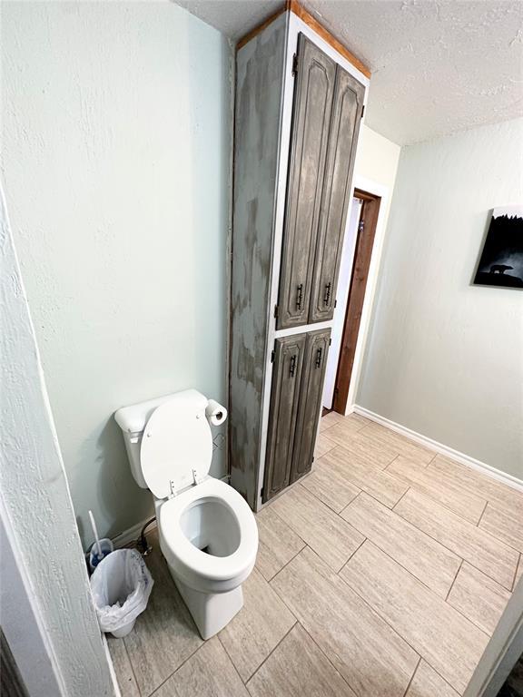 bathroom with toilet and a textured ceiling