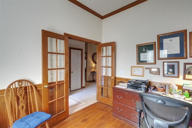 office with ornamental molding, light hardwood / wood-style floors, and french doors