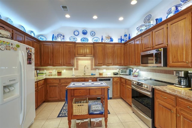 kitchen featuring tasteful backsplash, appliances with stainless steel finishes, sink, and light tile patterned floors