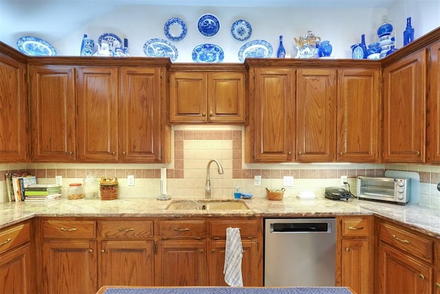 kitchen featuring sink, decorative backsplash, light stone countertops, and dishwasher