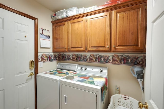 clothes washing area with cabinets and washing machine and clothes dryer