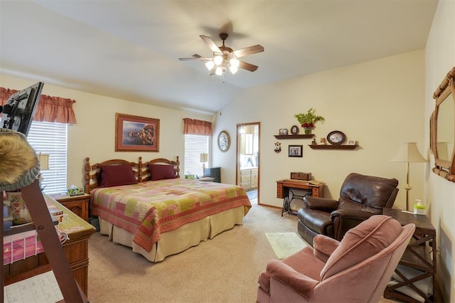 bedroom with vaulted ceiling, ceiling fan, light colored carpet, and ensuite bath