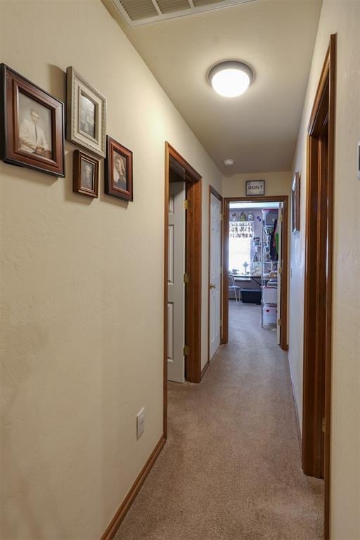 hall featuring light colored carpet