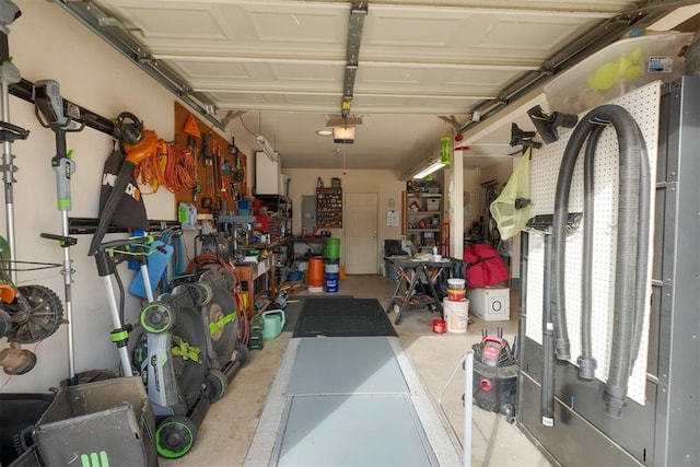 garage featuring a garage door opener, electric panel, and a workshop area