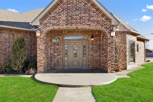 property entrance with a lawn