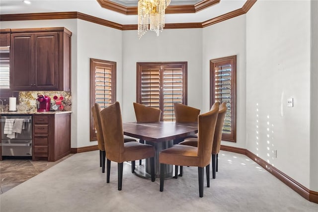 carpeted dining room featuring an inviting chandelier and crown molding