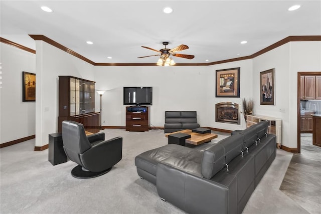 living room featuring ceiling fan, ornamental molding, and light carpet