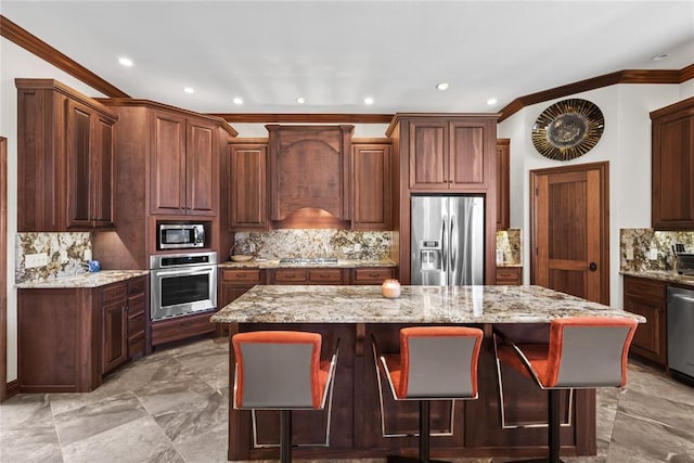 kitchen featuring a kitchen island, a breakfast bar area, decorative backsplash, stainless steel appliances, and light stone countertops