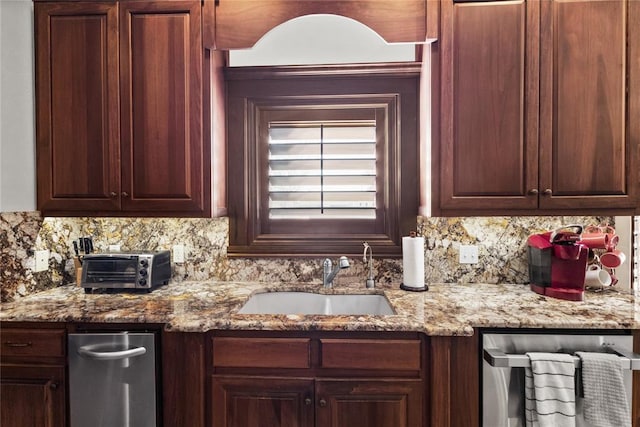 kitchen featuring sink, backsplash, light stone countertops, and stainless steel dishwasher