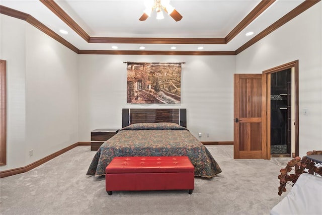 carpeted bedroom with crown molding, a walk in closet, and ceiling fan