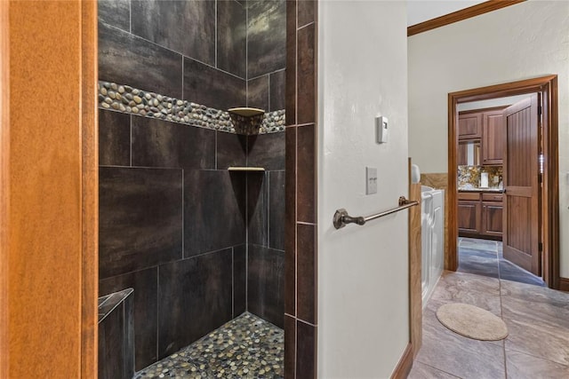 bathroom with crown molding and tiled shower