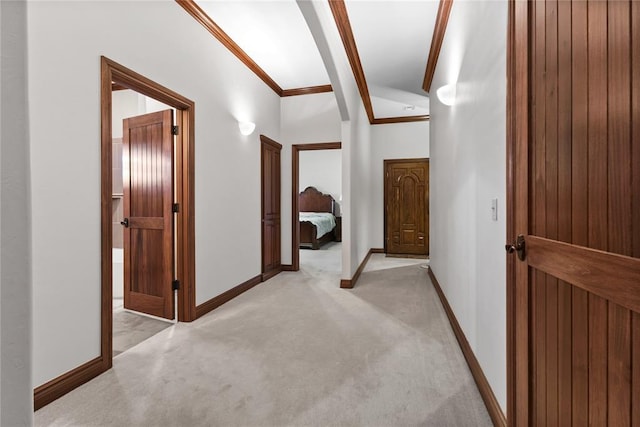 hall with crown molding, lofted ceiling, and light carpet