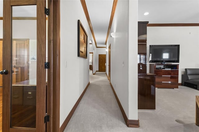 corridor with crown molding and light carpet