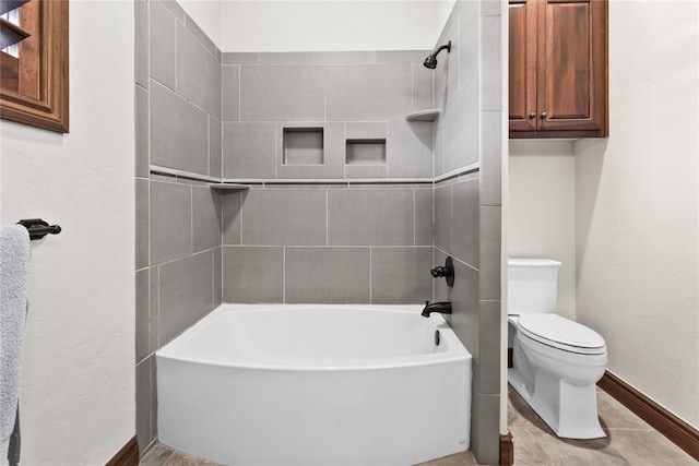 bathroom featuring tiled shower / bath combo and toilet