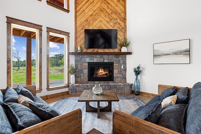 living room featuring a stone fireplace and light hardwood / wood-style flooring