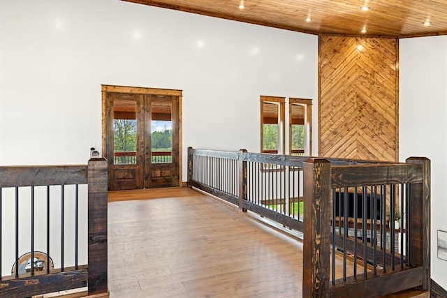 corridor featuring wood ceiling, a towering ceiling, french doors, and hardwood / wood-style flooring