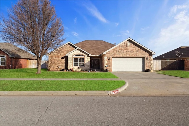 ranch-style house with concrete driveway, an attached garage, fence, a front yard, and brick siding