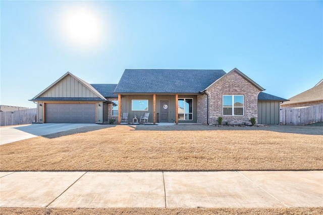 single story home featuring a garage, a porch, and a front yard