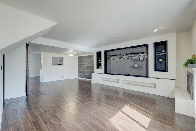 unfurnished living room featuring a brick fireplace and ceiling fan