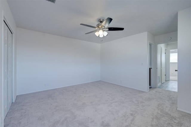 carpeted spare room with ceiling fan