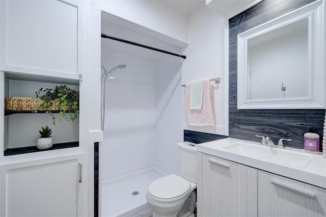 bathroom with vanity, walk in shower, and toilet