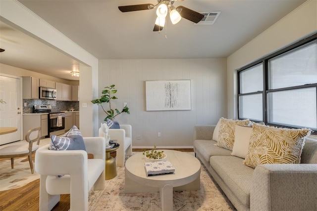 living room with ceiling fan and light hardwood / wood-style flooring