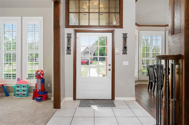 tiled foyer featuring crown molding and a wealth of natural light