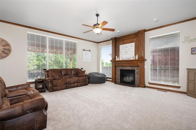 carpeted living room with a premium fireplace, ornamental molding, and ceiling fan